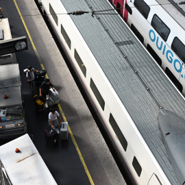 Varios usuarios caminan por los andenes de la Estación de Atocha, en Madrid, este martes, con un tren de Ouigo en las vías.