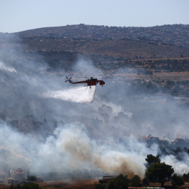Un helicóptero sofoca el gran fuego que incendia el pueblo de Rafina en Grecia, a 3 de julio de 2025.