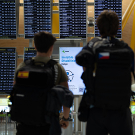 Dos personas observan las pantallas de información en el aeropuerto Adolfo Suárez Madrid-Barajas durante la primera operación salida del verano 2025, a 27 de junio de 2025, en Madrid (España).