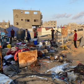 Personas inspeccionan el daño hecho por un ataque israelí en Jan Yunis en la Franja de Gaza el 2 de julio de 2025.