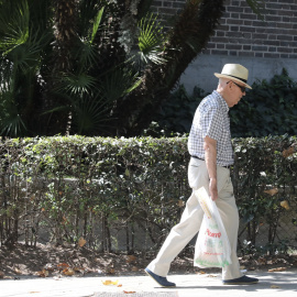 Un hombre de la tercera edad pasea por una calle de Madrid.