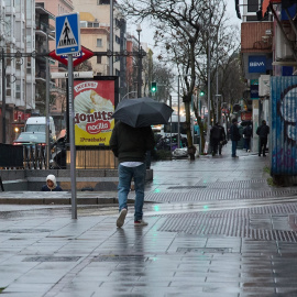 Un hombre se protege de la lluvia con un paraguas durante la borrasca ‘Karlotta’, a 9 de febrero de 2024, en Madrid (España).