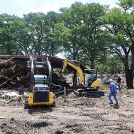 Personas recogen escombros en una zona afectada por las inundaciones este martes, en Hunt (Estados Unidos).