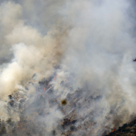 Un helicòpter treballa en les tasques d'extinció de l'incendi forestal de Paüls, aquest dimecres