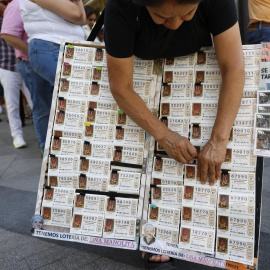 Una mujer vende décimos de lotería de Navidad,