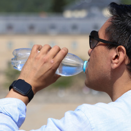 Un hombre bebe agua durante la ola de calor en Madrid.