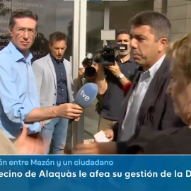 Carlos Mazón durante su conversación con el ciudadano Rafa Carceller, de espaldas.