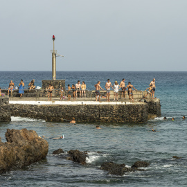 Varios bañistas se refrescan este martes en el muelle de Punta Mujeres, en Lanzarote.