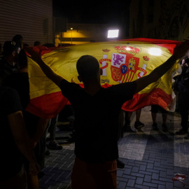 Un manifestante ondea una bandera de España mientras increpa a periodistas este martes en Torre Pacheco (Murcia).
