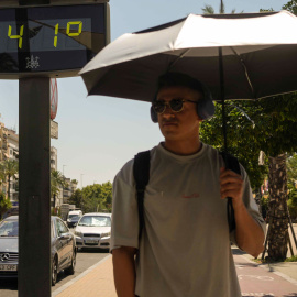 Un hombre camina este miércoles, junto a un termómetro del centro de Córdoba