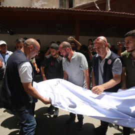 Los palestinos retiran el cuerpo de un ser querido para enterrarlo en el Hospital Árabe Ahli en Gaza.
