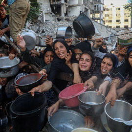 Palestinas esperan a recibir alimentos de un centro de distribución de ayuda humanitaria, en la ciudad de Gaza, el 14 de julio de 2025.