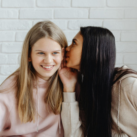 Dos amigas en edad adolescente comparten confidencias.