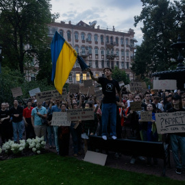 Los manifestantes sostienen una bandera nacional y pancartas durante la manifestación en Kiev este martes.