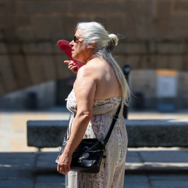 Una mujer se abanica ante la ola de calor en Madrid