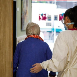 Una persona mayor sale de rehabilitación acompañada de un sanitaria