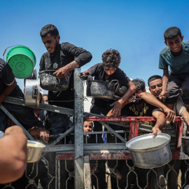 Palestinos esperan una comida distribuida por una organización benéfica.