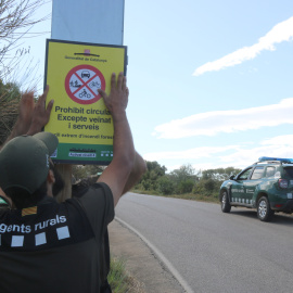 Dos agents rurals col·locant el cartell de prohibit el pas al Cap de Creus