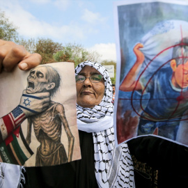 Una mujer muestra carteles que evocan la agonía de los palestinos en la Franja de Gaza, durante una protesta cerca de la embajada de Egipto, en Beirut, a 23 de julio de 2025.