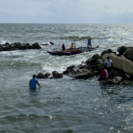 Pescadores de Cavite, en Filipinas, maniobran con su bote este miércoles durante la alerta de tsunami recién cancelada por las autoridades del país.