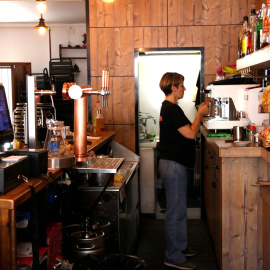 Una cambrera treballant a la barra del bar Can Peret de Tarragona
