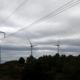 Una torre elèctrica aèria amb molins al costat a Rubió (Anoia)