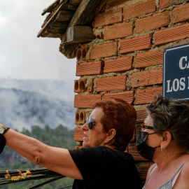 Dos vecinas de El Arenal, Ávila, observan el avance del fuego y el humo del incendio en el sur de la provincia.
