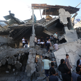 Palestinos entre ruinas en Al Nuseirat en la Franja de Gaza.