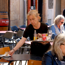 Una cambrera treballant en una terrassa d'un bar de la plaça de la Font a Tarragona
