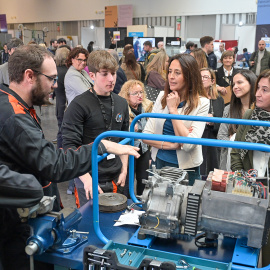 La consellera Esther Niubó escolta les explicacions d'un participant a la primera Fira de Formació Professional del Baix Llobregat, al mes de febrer