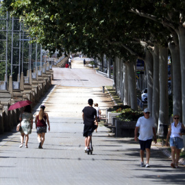 Vianants caminant per l'ombra a Lleida sota una intensa calor