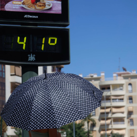 CÓRDOBA, 06/08/2025.- Una persona se protege del sol miemntras camina junto a un termómetro que marca 41 grados e Córdoba este miércoles, una jornada marcada por las altas temperaturas en casi todo el país. EFE/Salas