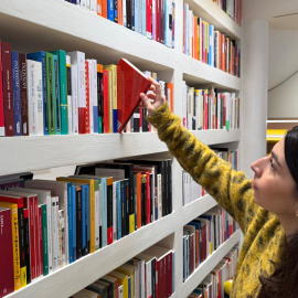 Una usuària agafa un llibre de la llibreria Finestres de Palamós