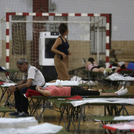 Vecinos de varias localidades desalojadas por los incendios, este martes en un pabellón de deportes de La Bañeza (León)