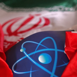 Una ilustración muestra el símbolo de la energía atómica junto a la bandera de Irán.