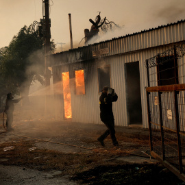Un bombero trabaja para extinguir un incendio forestal en un edificio en Sichaina, cerca de Patras, Grecia, el 13 de agosto de 2025.