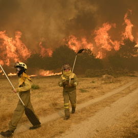 Residents try to battle a wildfire in the village of Santa Baia de Montes in the province of Ourense, northwestern Spain on August 14, 2025. Southern Europe continued to endure its hellish summer on Thursday, suffering from a heatwave that has now lasted almost two weeks and forest fires that have left a third person dead in Spain. (Photo by MIGUEL RIOPA / AFP)