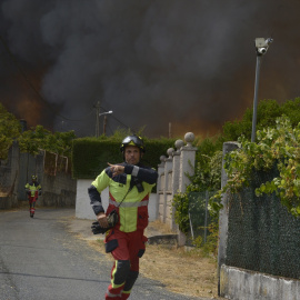 Dos bomberos colaboran en la extinción del incendio, a 12 de agosto de 2025, en Ourense.