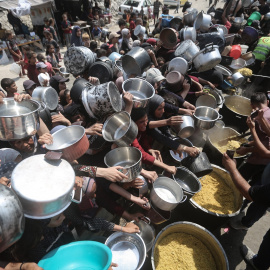 Palestinos esperan recibir comida de un comedor social.