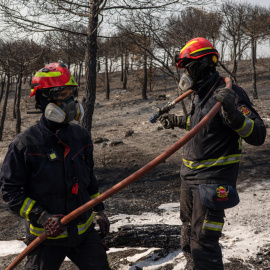 Bomberos enfrían un área quemada por el incendio en Colmenar Viejo.