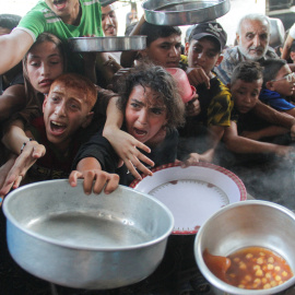Foto de archivo de niños palestinos que tratan de recibir comida preparada por una ONG, , en el norte de la Franja de Gaza.