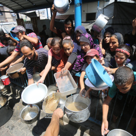 Palestinos esperan recibir comida de un comedor social.