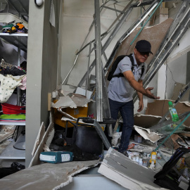 Un hombre camina entre los escombros del atentado en Cali.