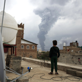 Un niño mira el humo tras los ataques israelíes en Saná (Irán).
