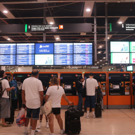 Viatgers esperant a les màquines d'autovenda de bitllets de Rodalies a l'estació de Sants