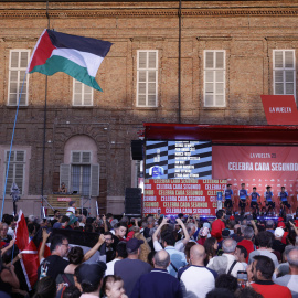 Un espectador ondea una bandera de Palestina mientras los corredores del equipo Israel participan en la presentación de la Vuelta Ciclista a España que comenzó 23/08/25 en Turín (Italia)