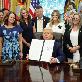 El presidente de EEUU, Donald Trump, sostiene una proclamación firmada rodeado de familiares de  militares fallecidos en Afganistán durante la retirada estadounidense en 2021, en el Despacho Oval de la Casa Blanca, en Washington DC.