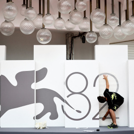 Un trabajador instala el logotipo del 82º Festival de Cine de Venecia.
