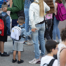 Varios niños esperan para entrar al colegio el primer día de curso escolar
