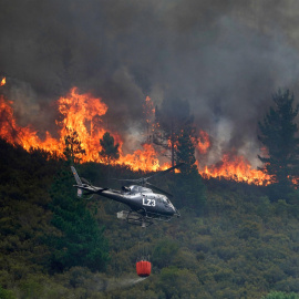 Un helicóptero en labores de extinción del incendio que afecta a los alrededores de San Antolín de Ibias este miércoles. EFE/Paco Paredes